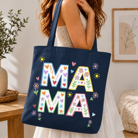Navy tote bag with colorful 'MAMA' letters held by a person in a home setting.
