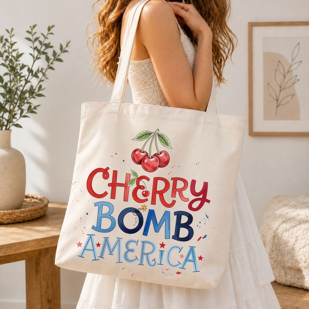 Person holding a tote bag with 'Cherry Bomb America' design in a home setting