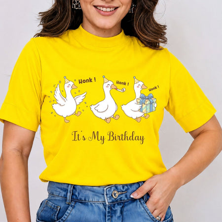 Smiling person wearing a bright yellow t-shirt featuring the funny "It's My Birthday" party geese graphic and typography.