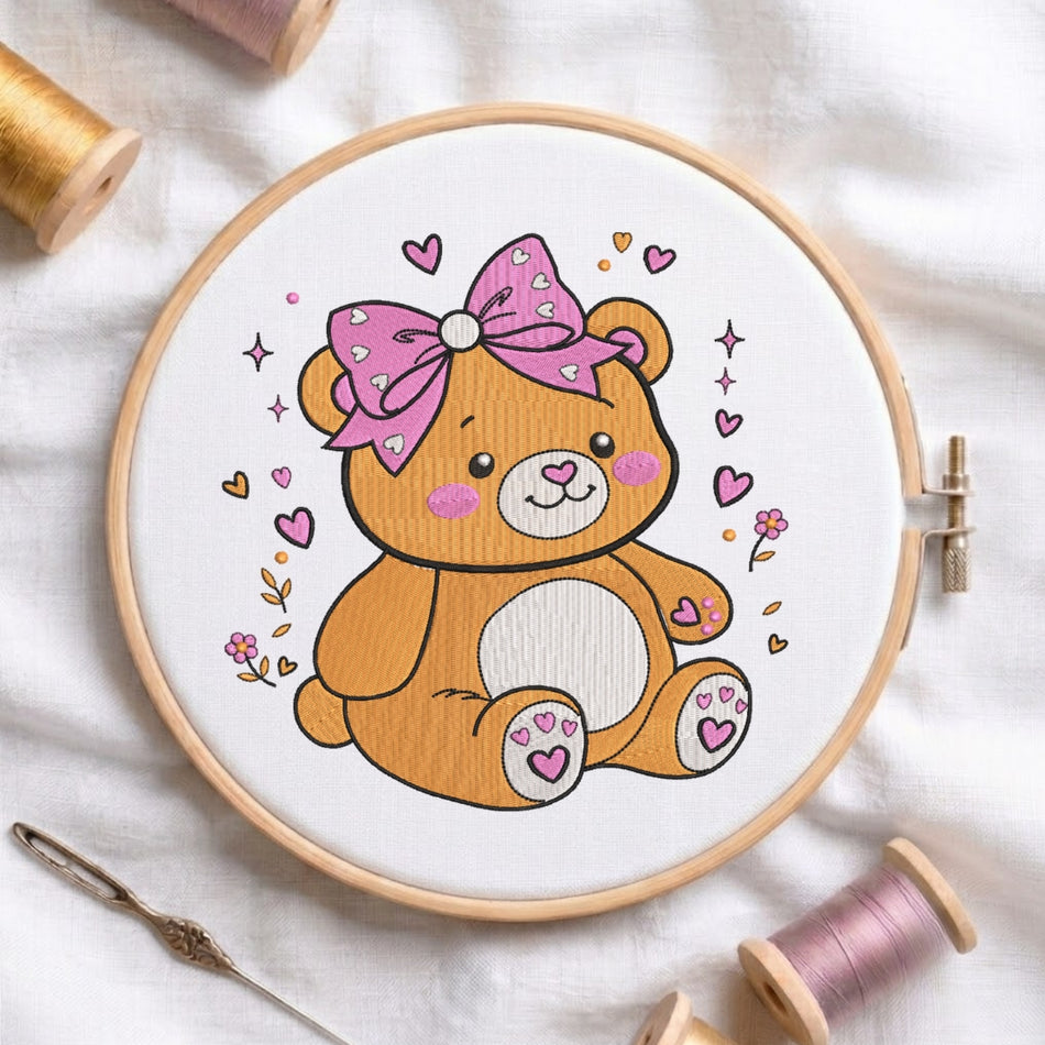 Cute teddy bear with a pink bow machine embroidery design in a wooden hoop.