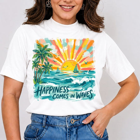 A woman wearing a white short-sleeve t-shirt with a colorful graphic print of a tropical sunset, palm trees, sailboats, and the text 'HAPPINESS COMES IN WAVES', paired with blue jeans.