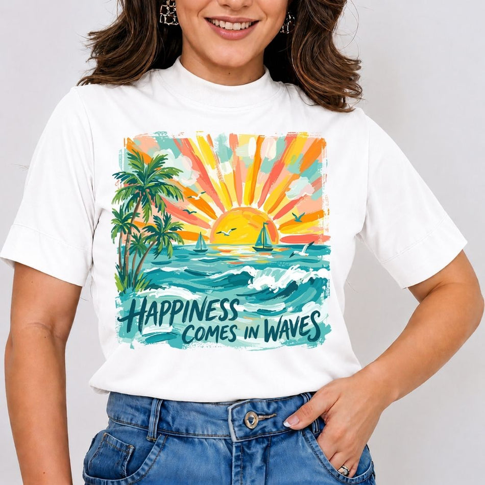 A woman wearing a white short-sleeve t-shirt with a colorful graphic print of a tropical sunset, palm trees, sailboats, and the text 'HAPPINESS COMES IN WAVES', paired with blue jeans.