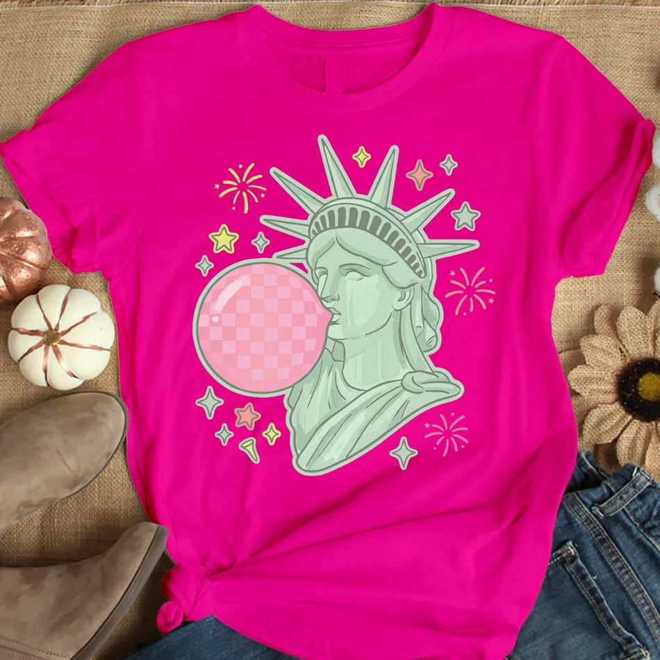 Pink t-shirt with Statue of Liberty graphic on a textured surface
