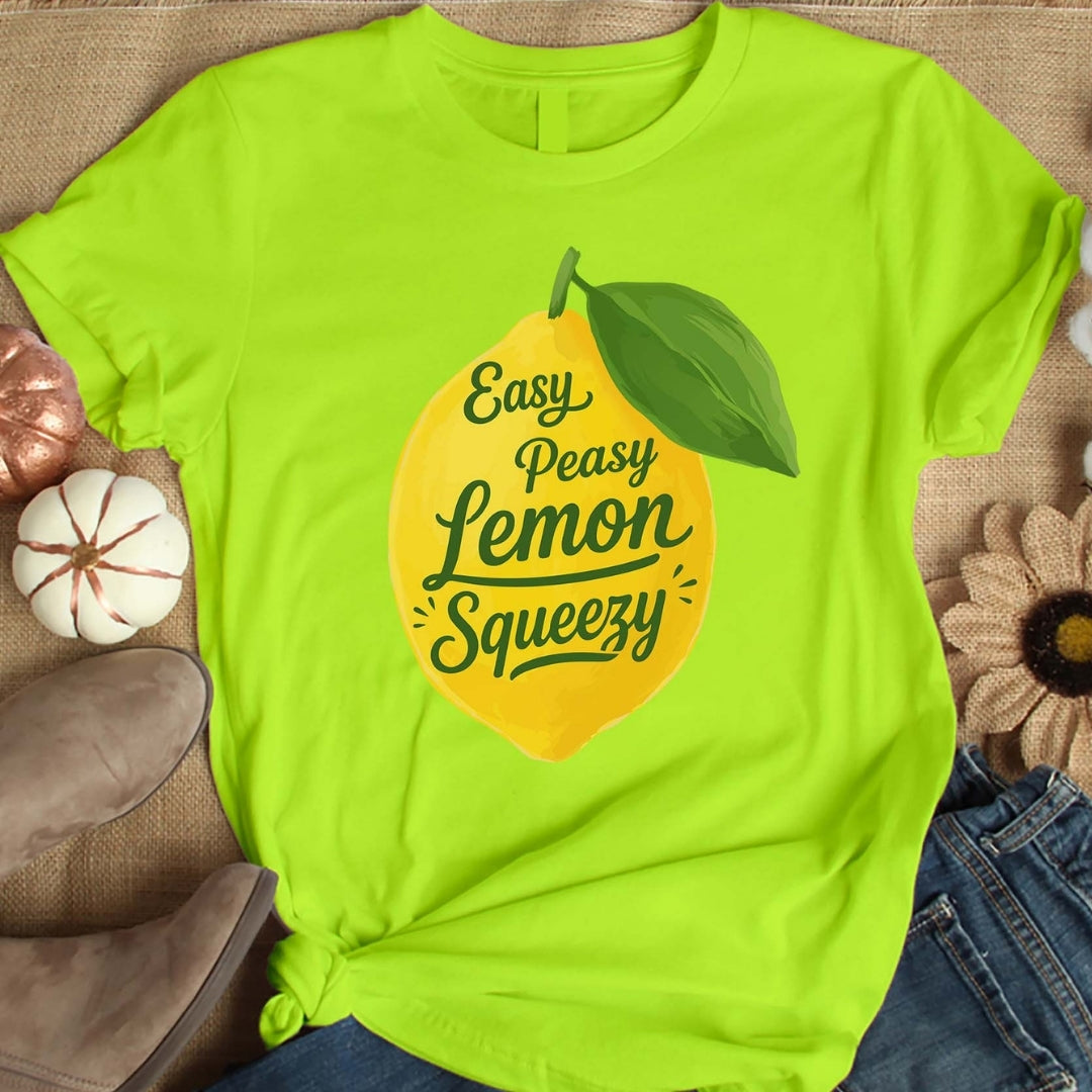 Bright green t-shirt with lemon graphic and text on a textured surface