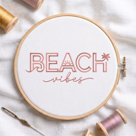 The "Beach Vibes" embroidery design centered in a wooden embroidery hoop, surrounded by embroidery thread spools and a needle.
