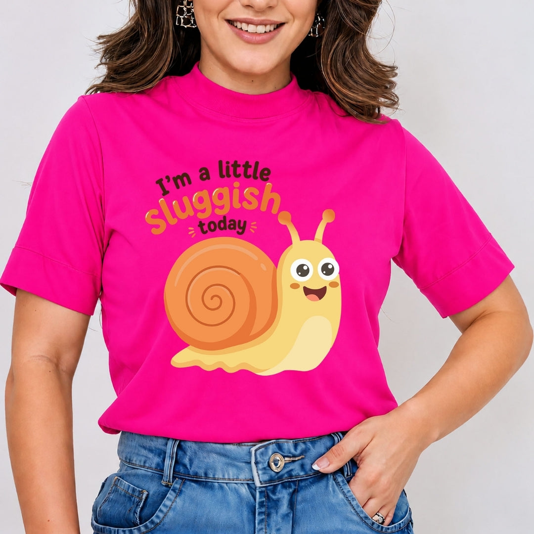 A person wearing a bright hot-pink t-shirt featuring the cute, smiling cartoon snail graphic and the text "I’m a little sluggish today."