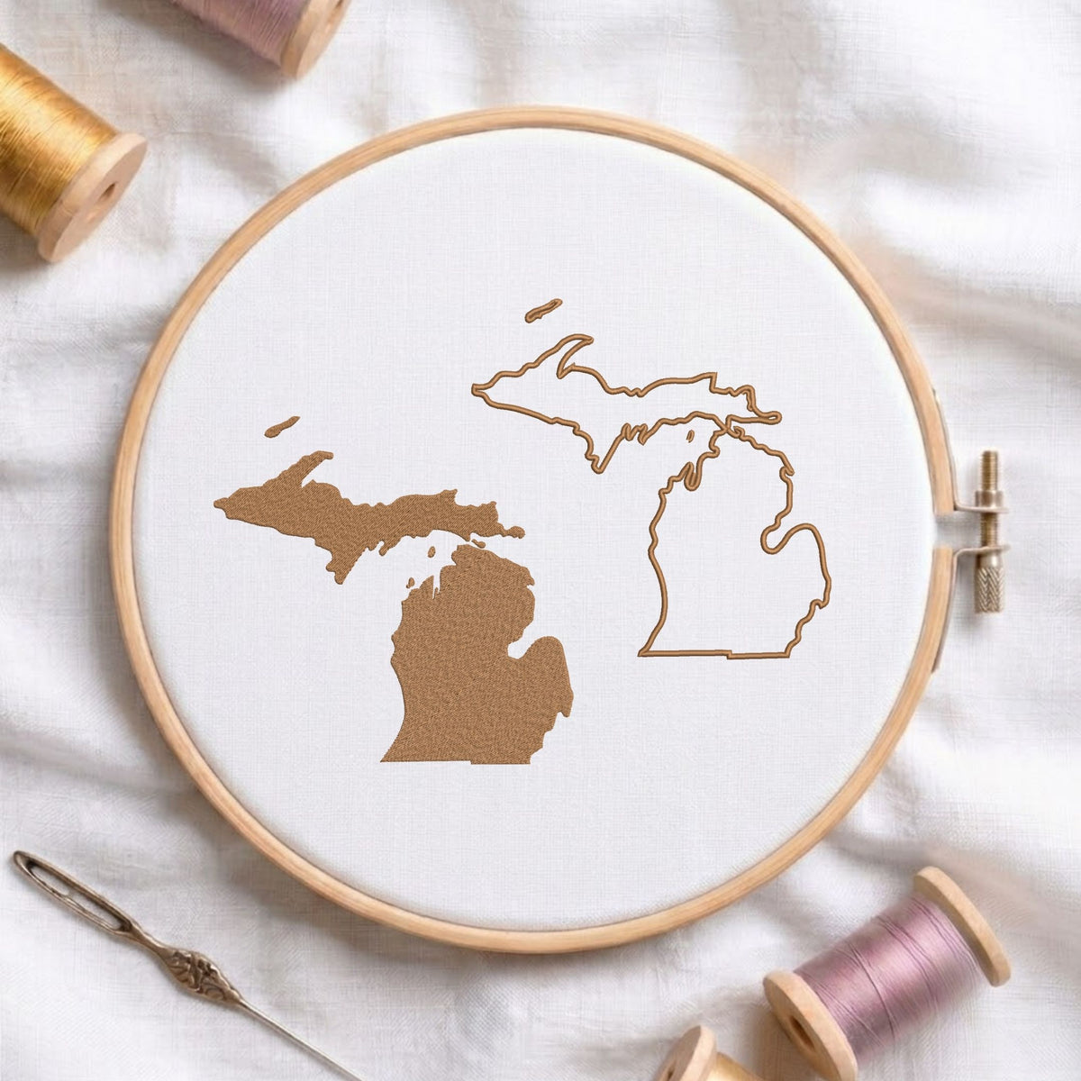 Michigan state map fill and outline machine embroidery design, displayed in a wooden hoop on white fabric with thread spools and a needle.