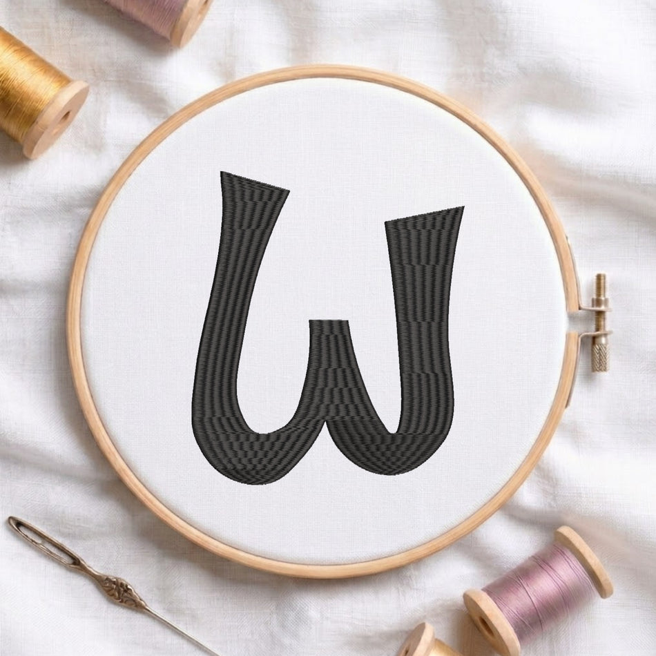 A wooden embroidery hoop holding white fabric with a large black letter W stitched in a striped pattern, styled on a white fabric background with embroidery threads and a needle.