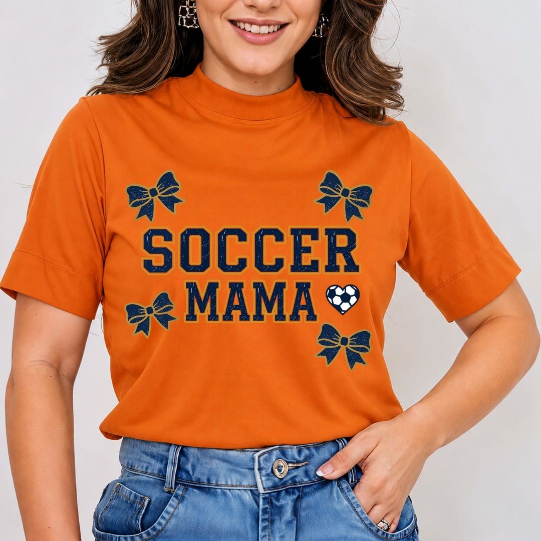 Person wearing an orange 'Soccer Mama' t-shirt with decorative elements on a plain background