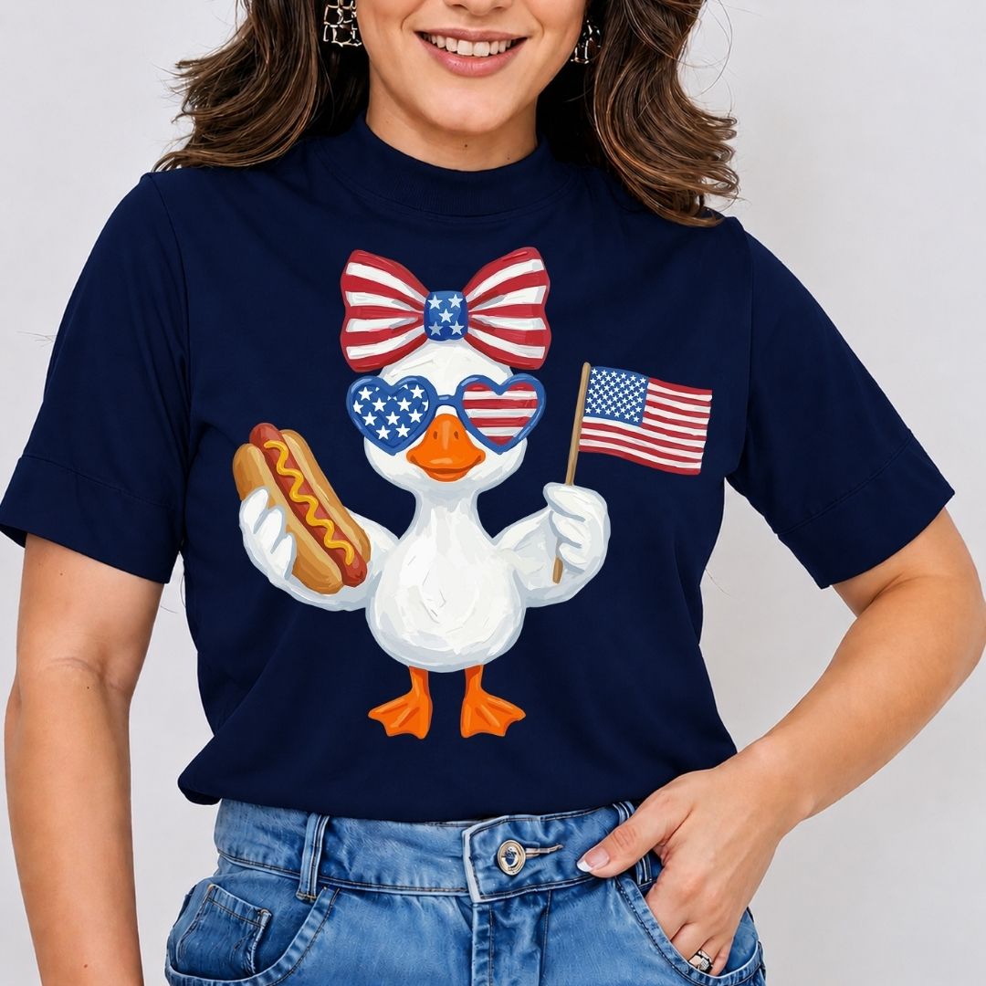 Person wearing a navy blue t-shirt with a patriotic duck graphic holding an American flag and a hot dog.