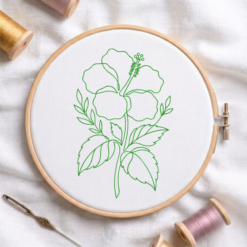 The hibiscus embroidery design is secured in a wooden embroidery hoop, displayed alongside embroidery thread spools and a needle on a white fabric background.