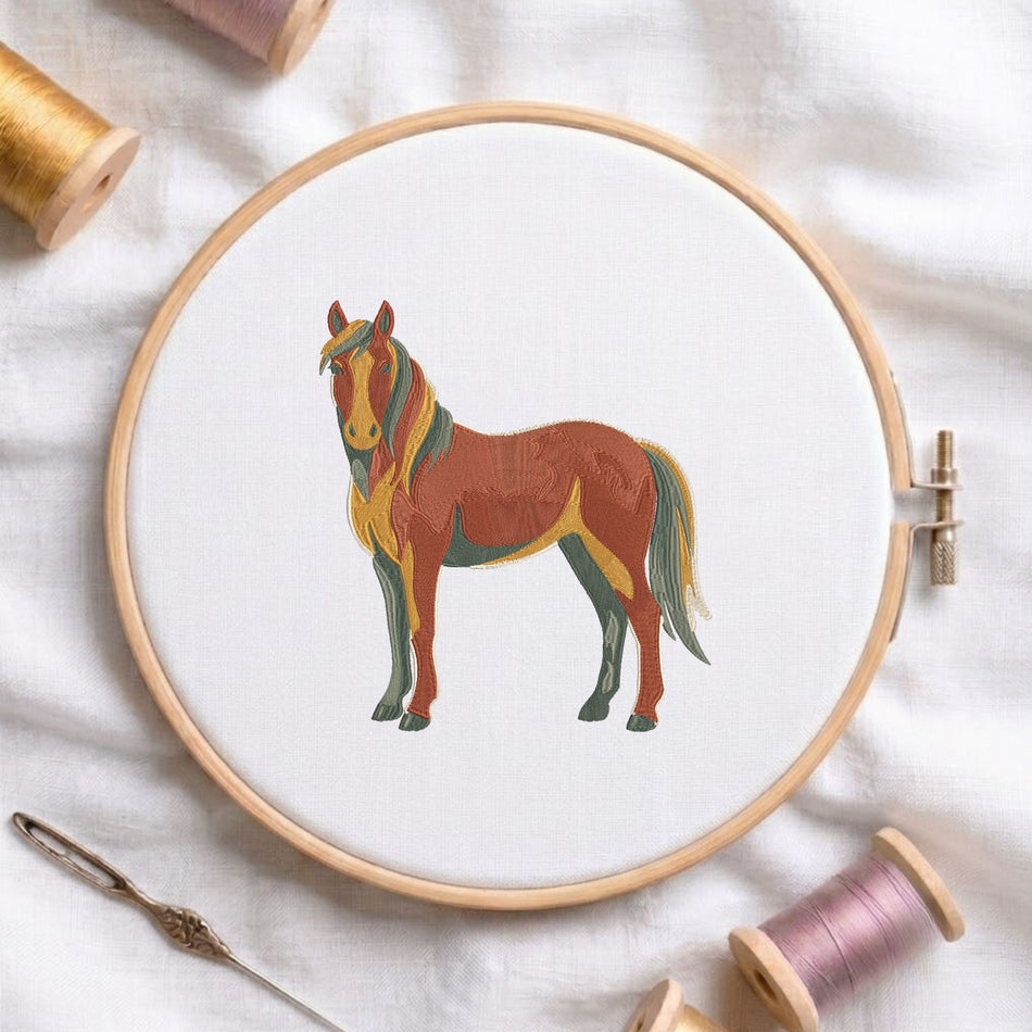 Vibrant stylized horse machine embroidery design displayed inside a round wooden hoop on white fabric alongside thread spools and a needle.