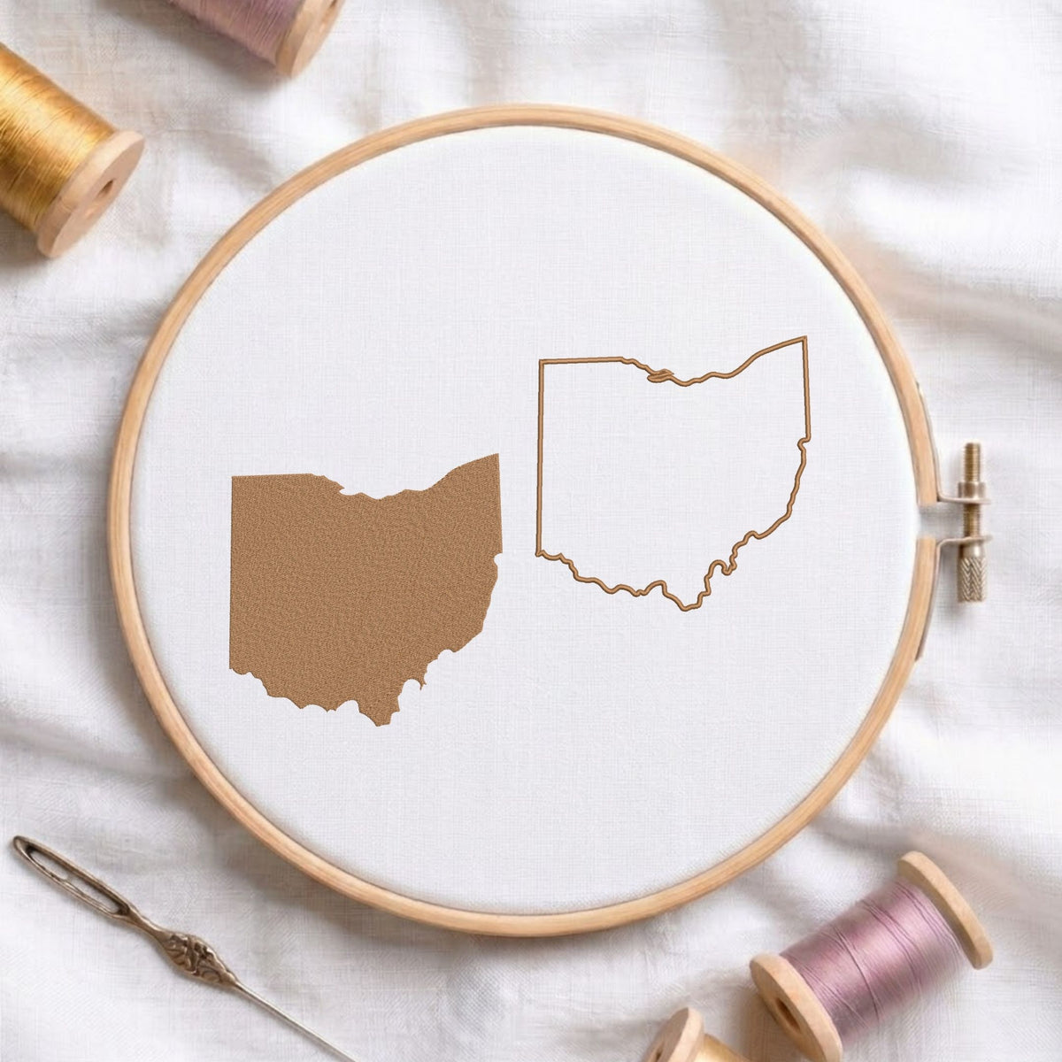 Ohio state map fill and outline machine embroidery design, displayed in a wooden hoop on white fabric with thread spools and a needle.   