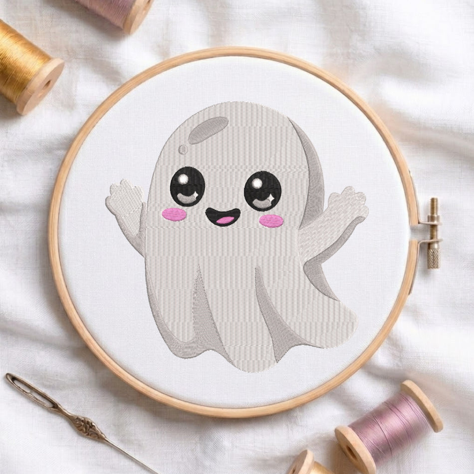 The cute ghost embroidery design centered in a wooden embroidery hoop, surrounded by embroidery thread spools and a needle.