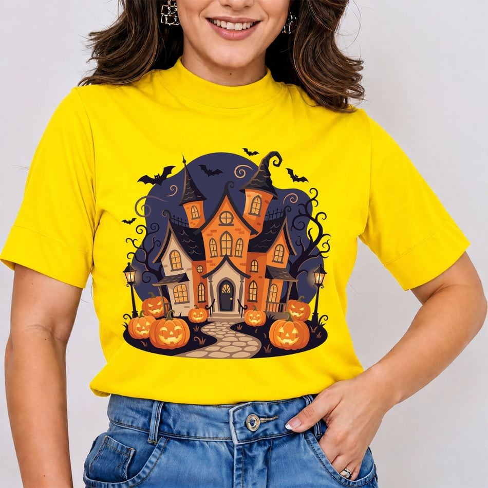 A woman wearing a bright yellow short-sleeve t-shirt with a graphic of a haunted house surrounded by pumpkins and bats, paired with blue jeans.