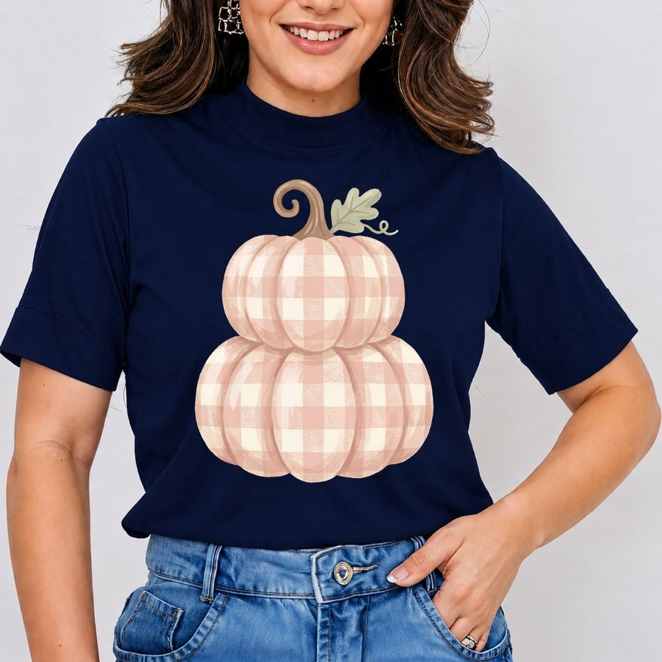 Person wearing a navy blue t-shirt with a pink gingham pumpkin design on a plain background