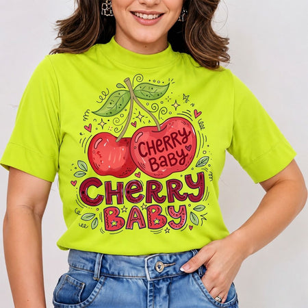 A woman wearing a bright lime green mock-neck t-shirt with a cartoon cherry graphic and the text 'Cherry Baby' in red, paired with blue jeans.