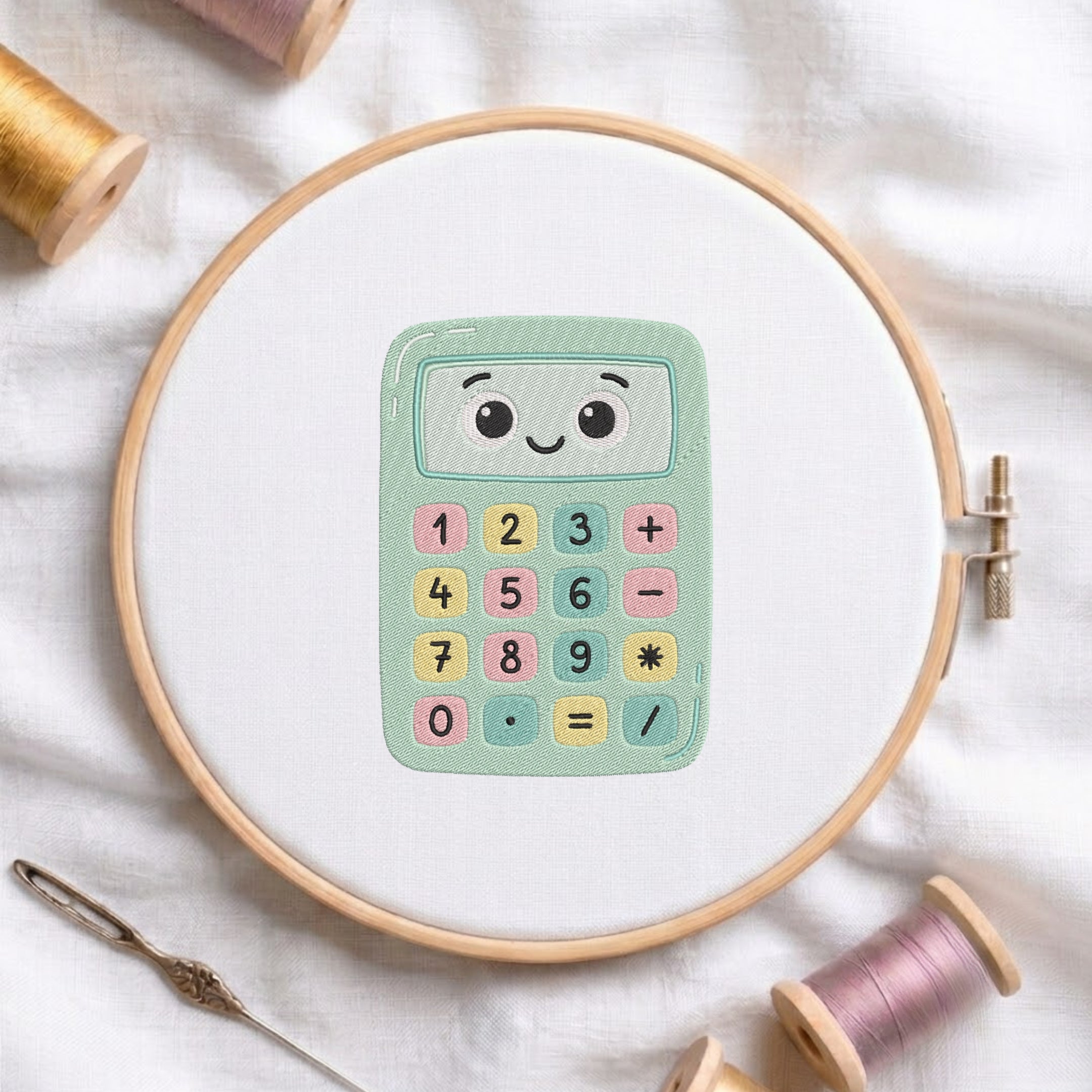 A wooden embroidery hoop holds a white fabric with a colorful cartoon calculator design in the center. The scene is styled with spools of thread and a needle on a soft white fabric background.