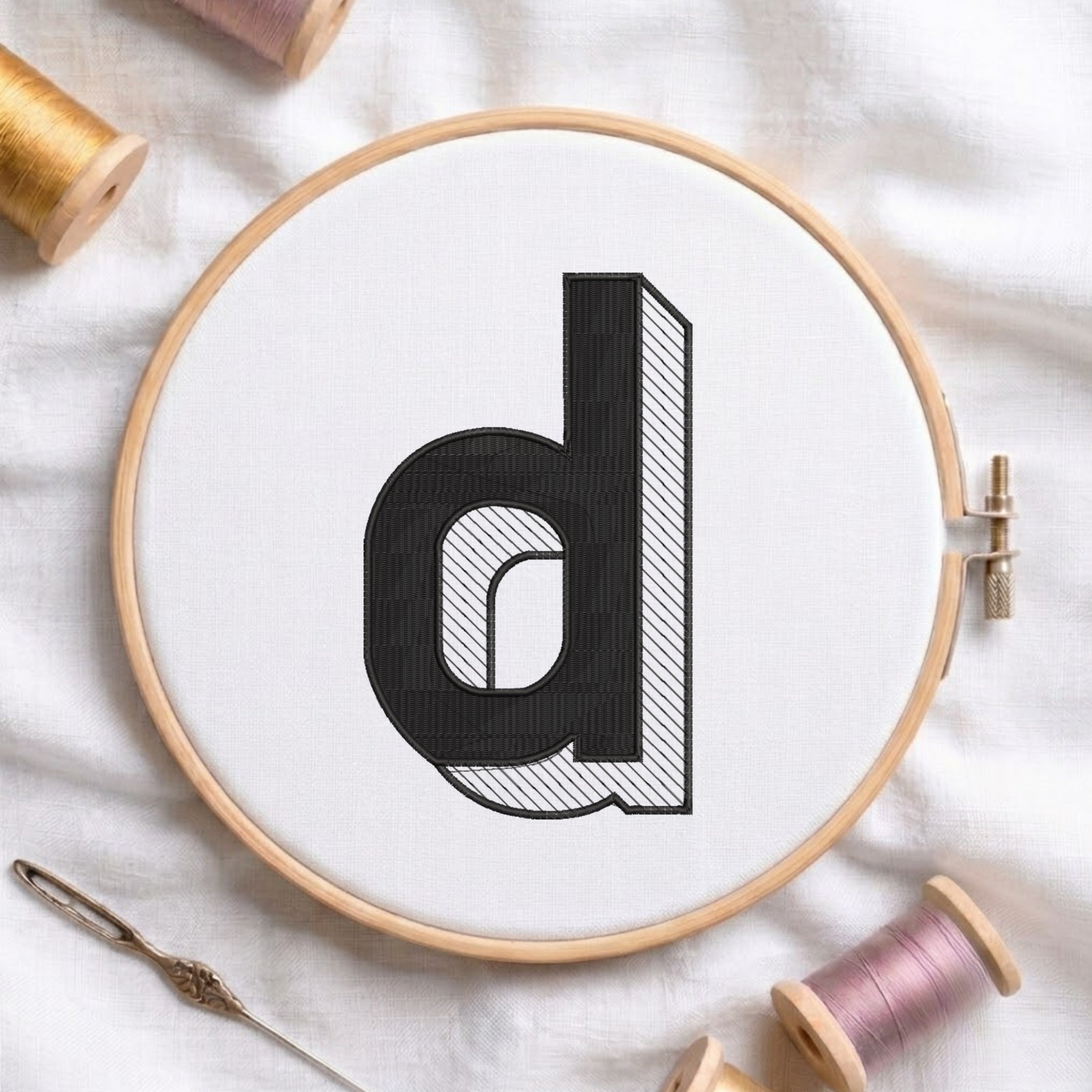 An embroidered 3D block lowercase letter "d" with striped shading texture, stitched inside a wooden hoop on white fabric with sewing threads.