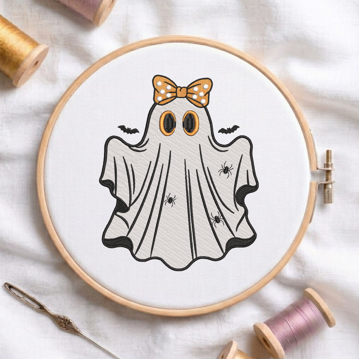 Embroidered friendly Halloween ghost wearing an orange polka dot bow in a wooden hoop.