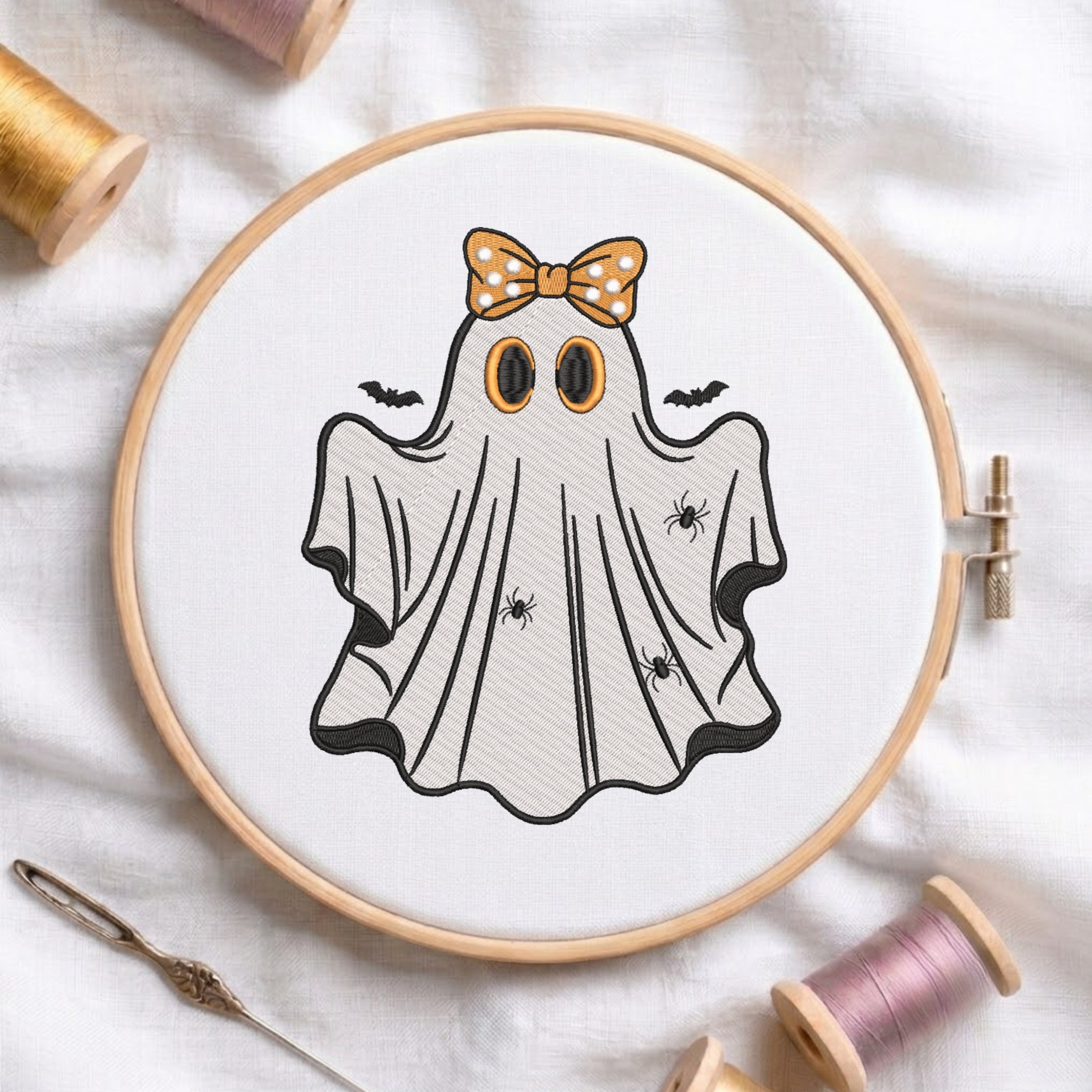 Embroidered friendly Halloween ghost wearing an orange polka dot bow in a wooden hoop.