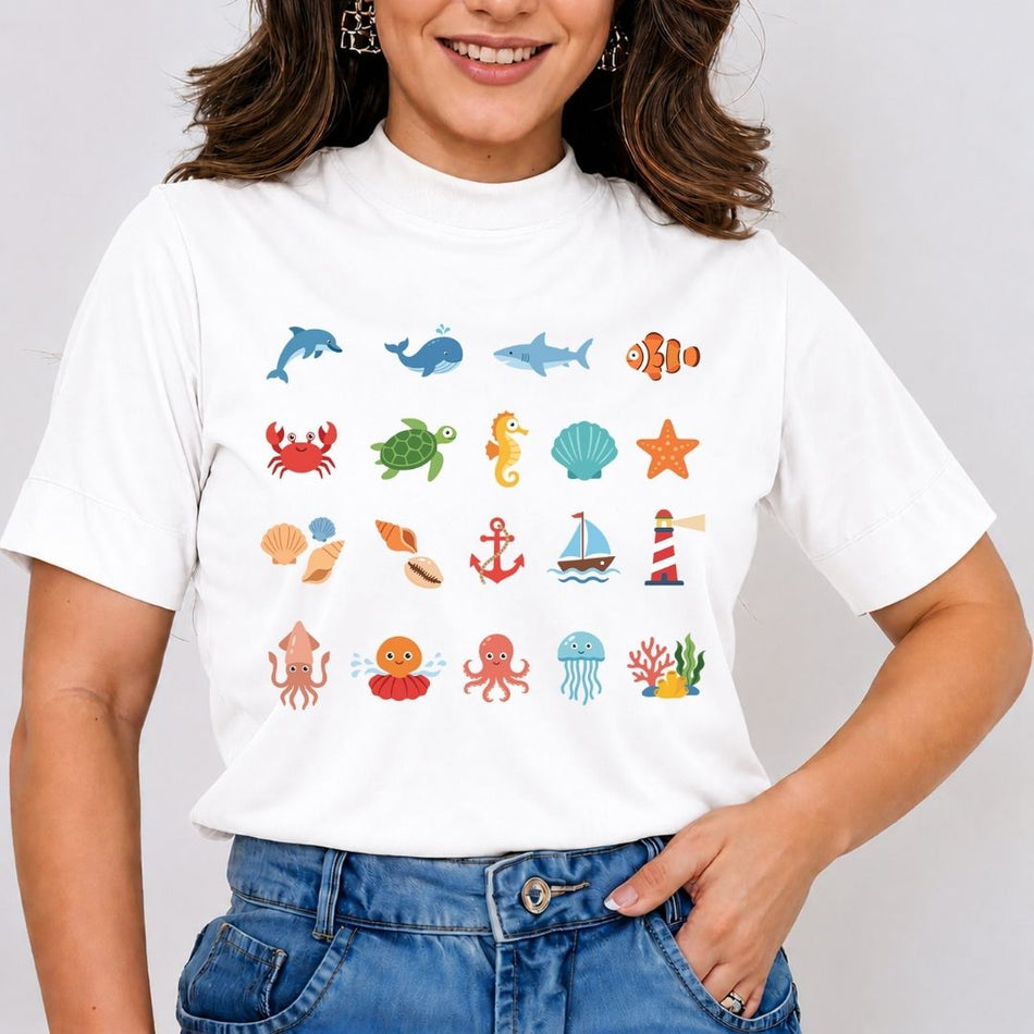 A woman wearing a white short-sleeve t-shirt with a colorful grid of ocean-themed illustrations, paired with blue jeans, against a light gray background.