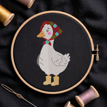 Goose wearing a red floral kerchief babushka and yellow rainboots embroidery design inside a wooden hoop on dark fabric.