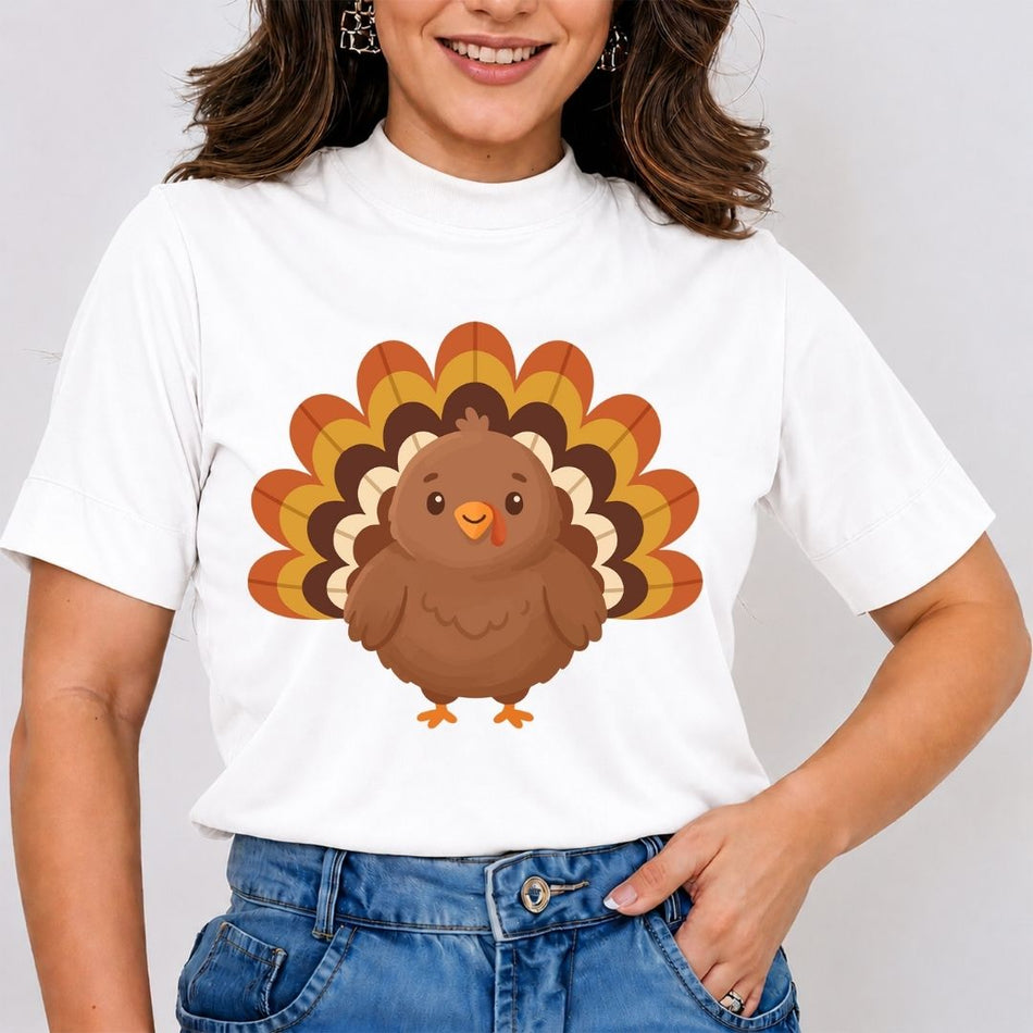A woman wearing a white short-sleeve t-shirt with a cartoon turkey graphic on the front, paired with blue jeans, against a light gray background.
