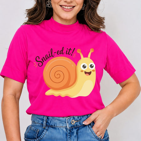 A close-up of a person wearing a hot pink t-shirt featuring a smiling cartoon snail graphic and the text "Snail-ed it!".