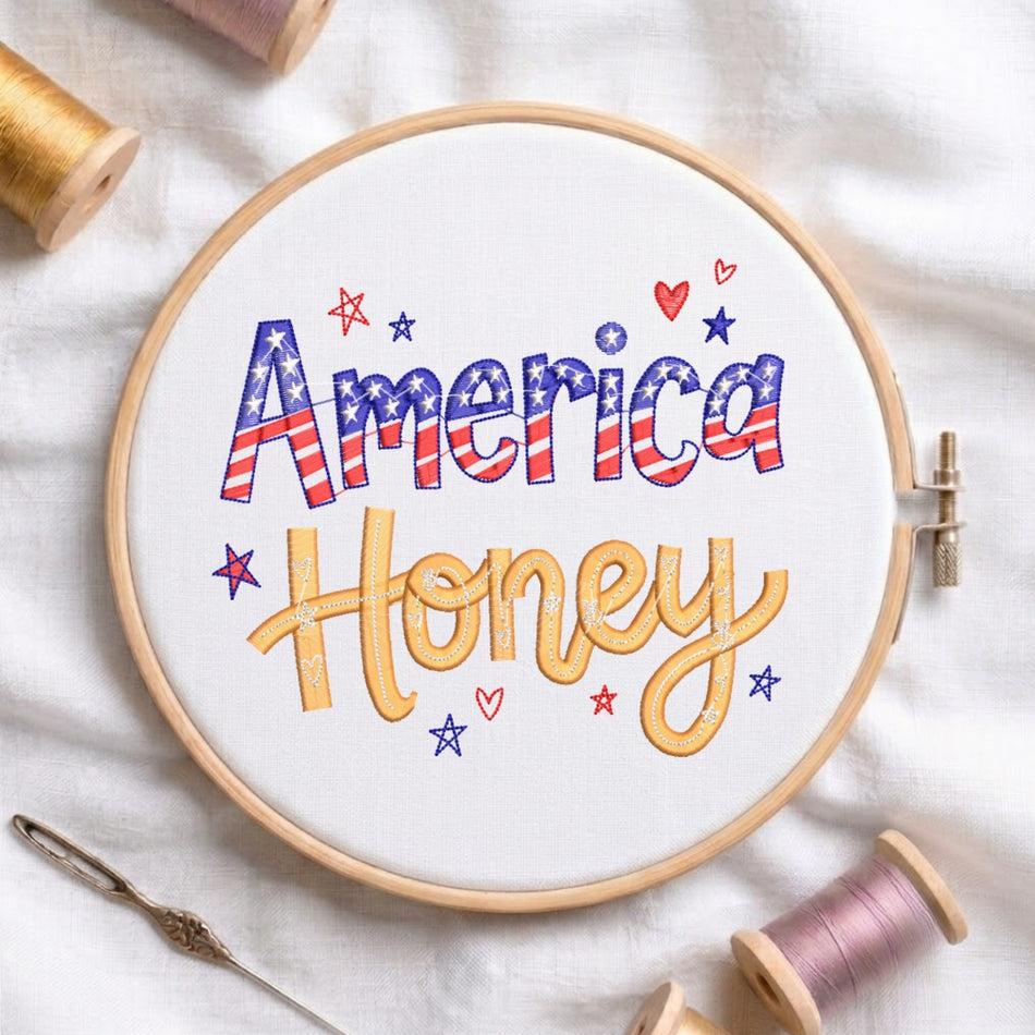 The "It’s a Good Day to Have a Good Day" embroidery design centered in a wooden embroidery hoop, surrounded by embroidery thread spools and a needle.