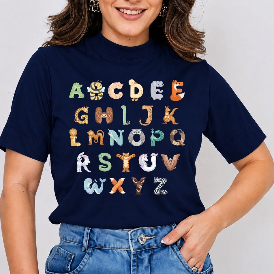 Smiling person wearing a dark blue t-shirt featuring a colorful alphabet from A to Z, with each letter cleverly designed as a cute animal (e.g., A is an alligator, B is a bee).