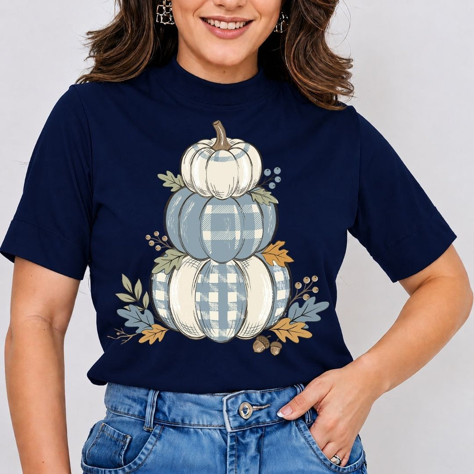 Person wearing a navy blue t-shirt with a pumpkin design on a plain background