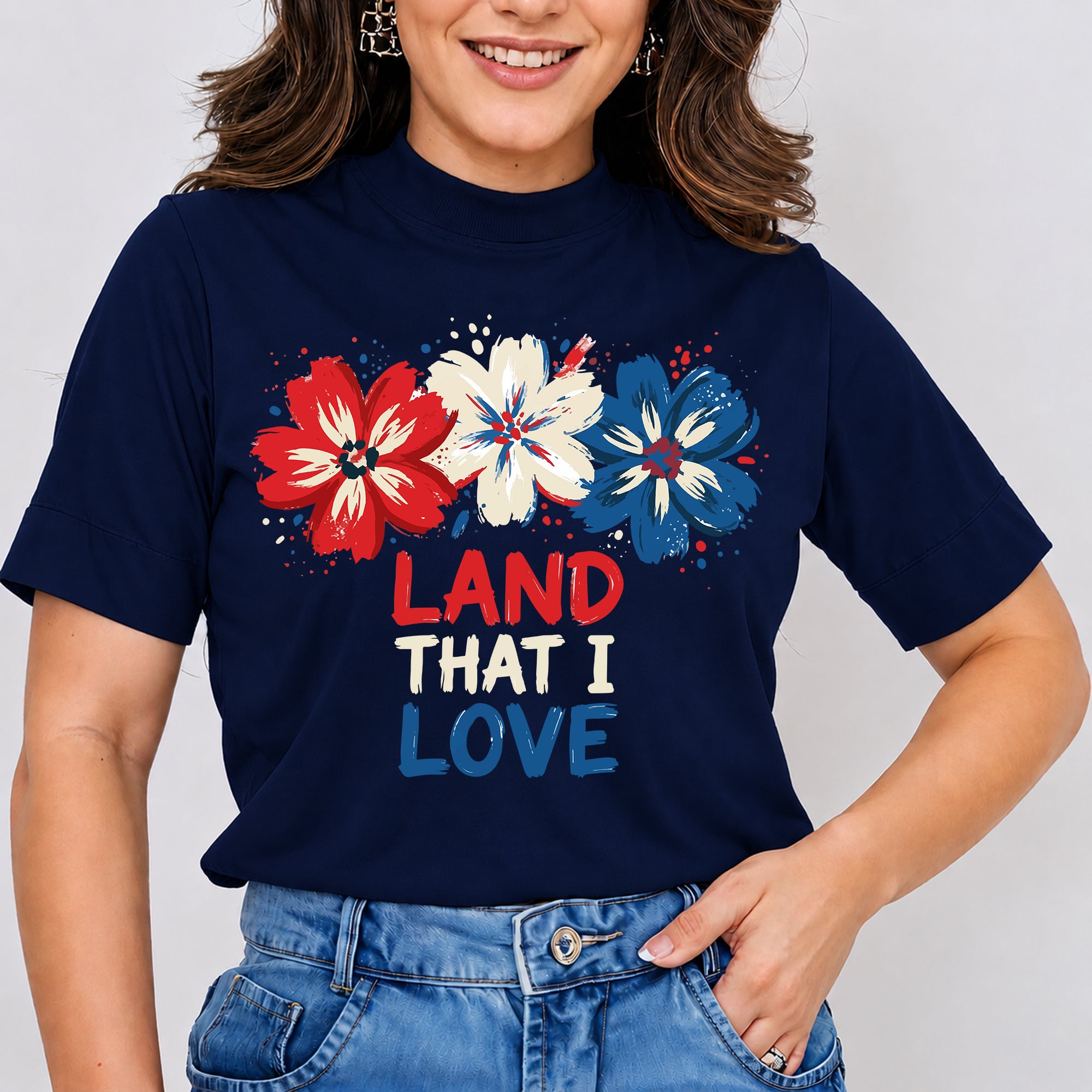 Person wearing a navy blue t-shirt with red, white, and blue flowers and 'LAND THAT I LOVE' text.
