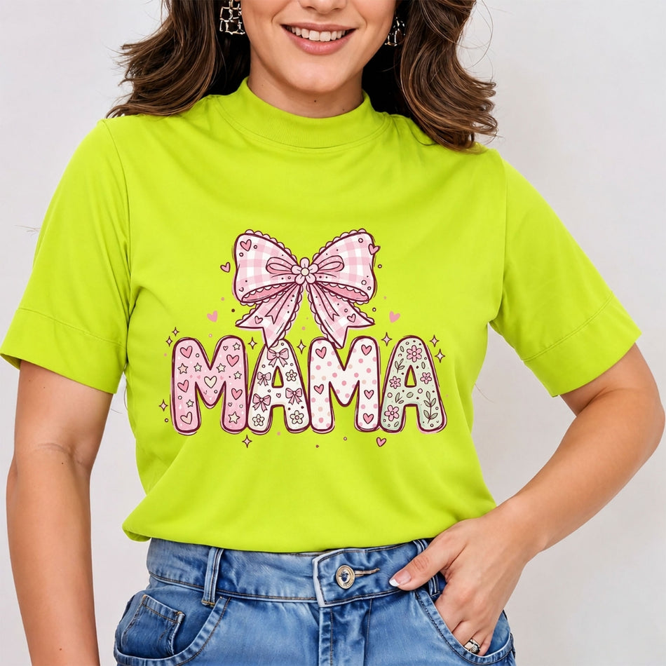 Woman wearing a bright lime green mock neck t-shirt featuring a doodle-style "MAMA" graphic design filled with hearts and stars, topped with a pink gingham coquette bow.
