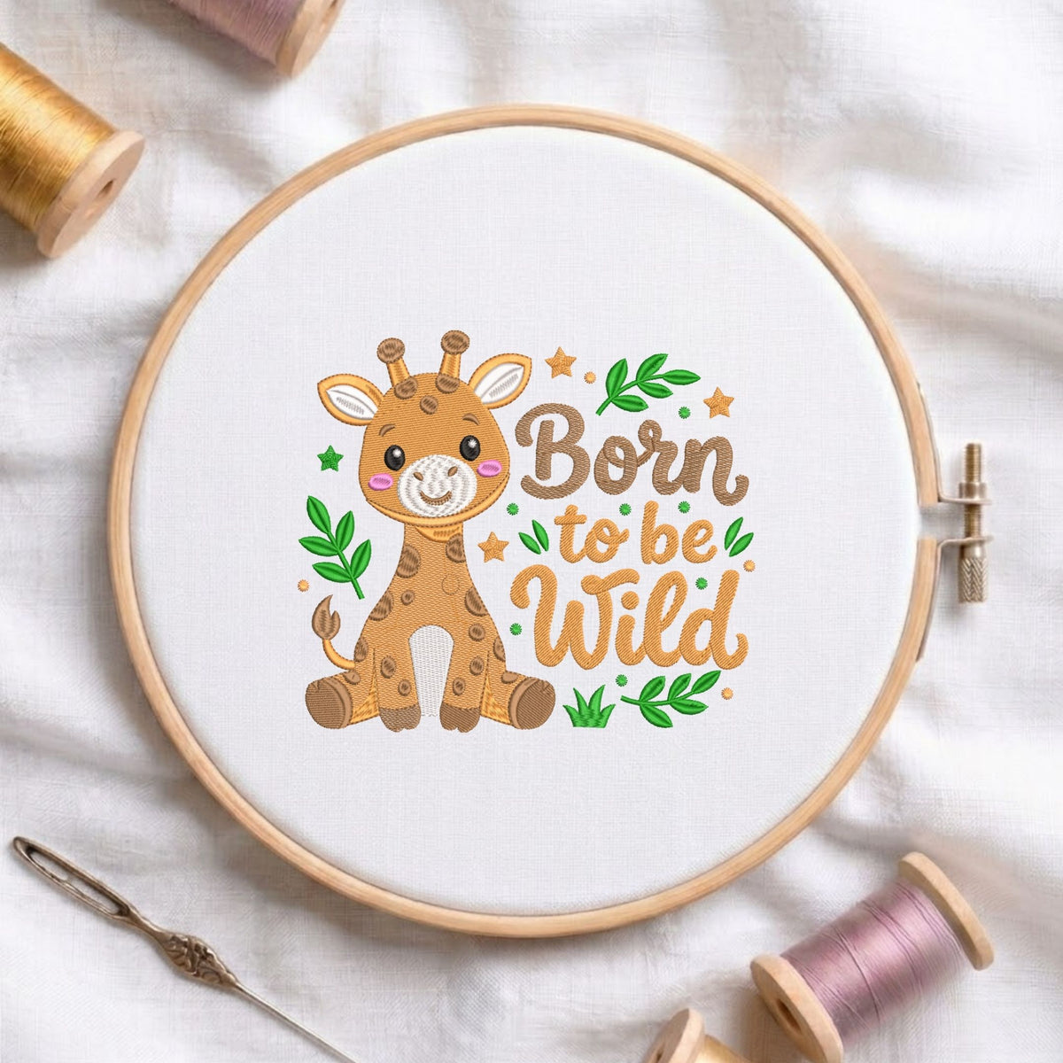 "Born to be wild" cute safari baby giraffe machine embroidery design displayed in a wooden hoop on white fabric with thread spools and a needle