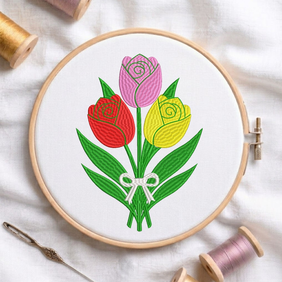 Embroidery hoop with a colorful tulip design on a white fabric background.