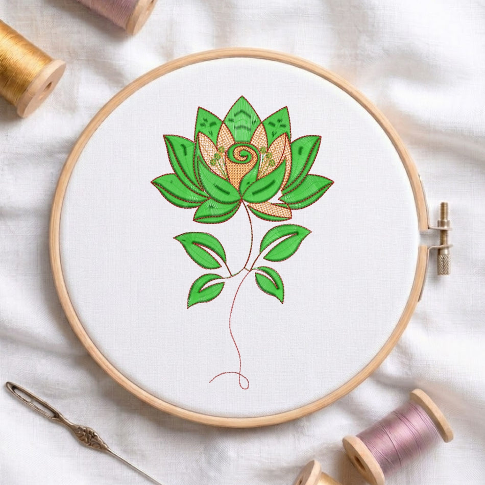 A wooden embroidery hoop holding white fabric with a stylized lotus flower stitched in green and peach thread, surrounded by spools of thread and a needle on a white fabric background.