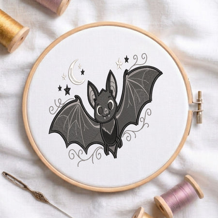 Cute embroidered bat with moon and stars in a wooden hoop.