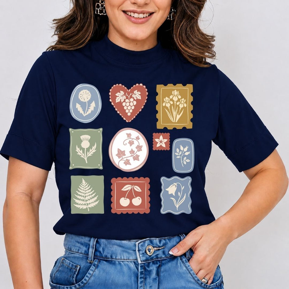 Woman wearing a dark navy blue t-shirt printed with a grid of vintage botanical and floral stamp illustrations.