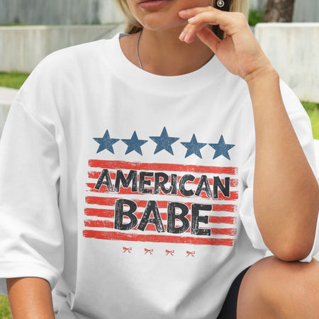 Person wearing a white t-shirt with 'American Babe' graphic design.