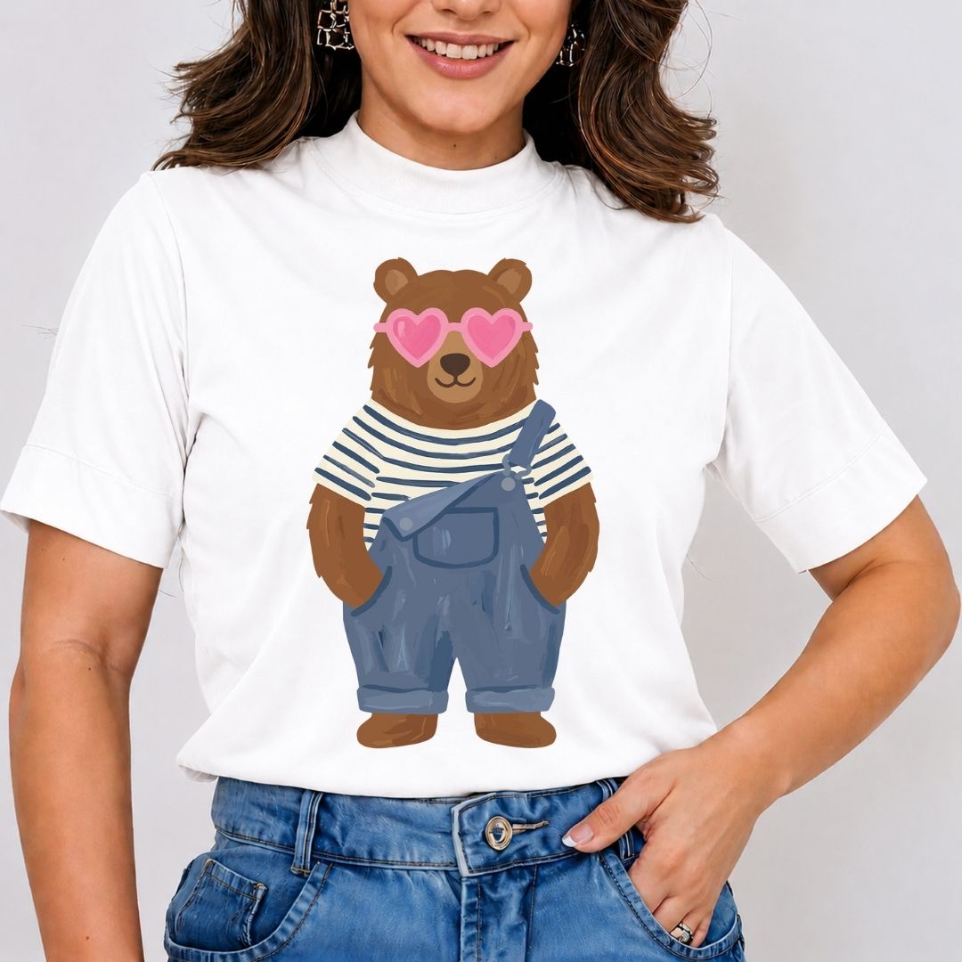Person wearing a white t-shirt with a bear graphic and pink heart sunglasses on a plain background
