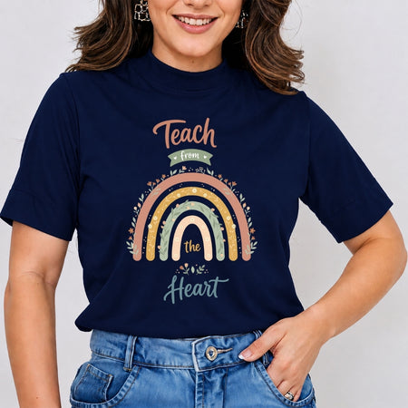 A woman wearing a navy blue graphic t-shirt with a colorful rainbow design and the text 'Teach from the Heart'.