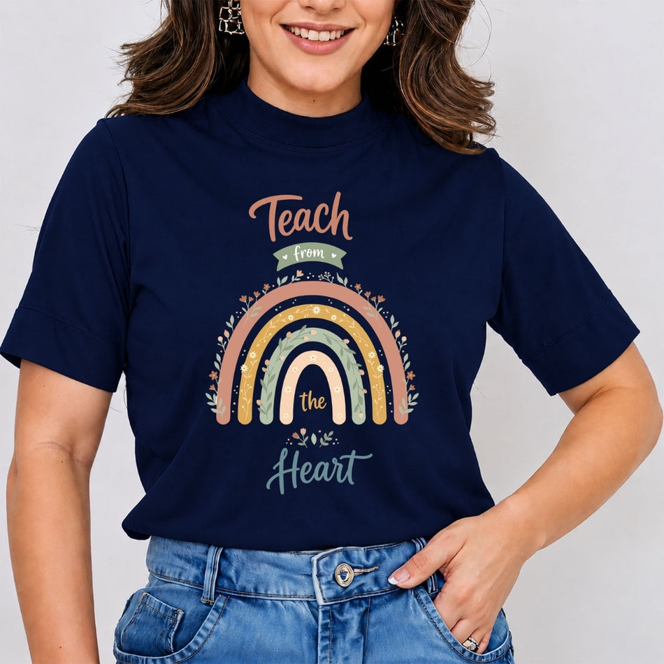 A woman wearing a navy blue graphic t-shirt with a colorful rainbow design and the text 'Teach from the Heart'.
