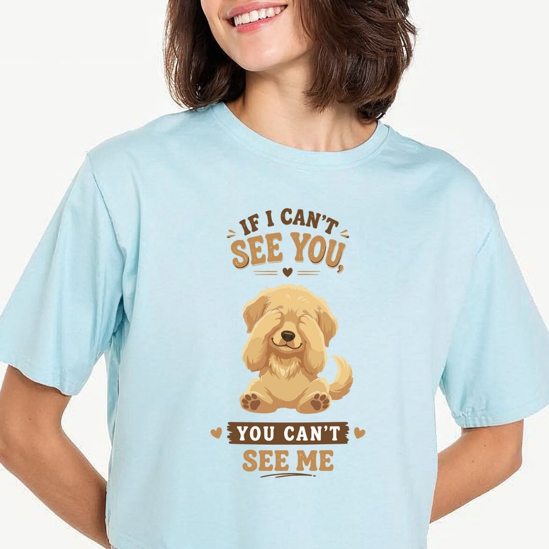 Person carrying a canvas tote bag featuring a cute golden retriever puppy covering its eyes with the funny quote, "IF I CAN'T SEE YOU, YOU CAN'T SEE ME".