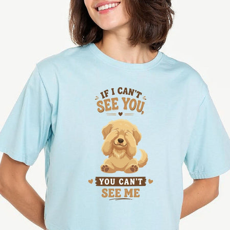 Person carrying a canvas tote bag featuring a cute golden retriever puppy covering its eyes with the funny quote, "IF I CAN'T SEE YOU, YOU CAN'T SEE ME".
