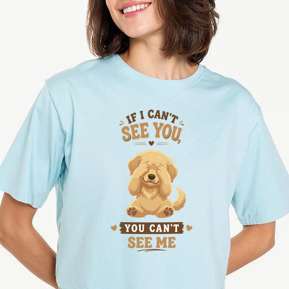 Person carrying a canvas tote bag featuring a cute golden retriever puppy covering its eyes with the funny quote, "IF I CAN'T SEE YOU, YOU CAN'T SEE ME".