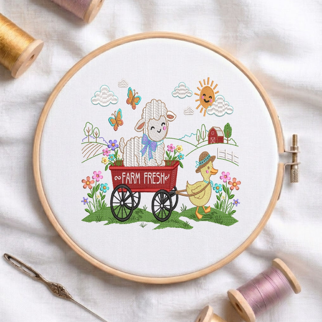 A circular embroidery hoop holding white fabric with a colorful embroidered farm scene: a white lamb in a red wagon, a yellow duck, flowers, butterflies, clouds, and a sun. The hoop is styled on white fabric with spools of thread, a needle, and other embroidery supplies around it.
