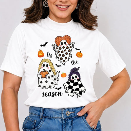 Woman wearing a white t-shirt featuring a "Tis the Season" Hocus Pocus ghost and Sanderson sisters Halloween design.