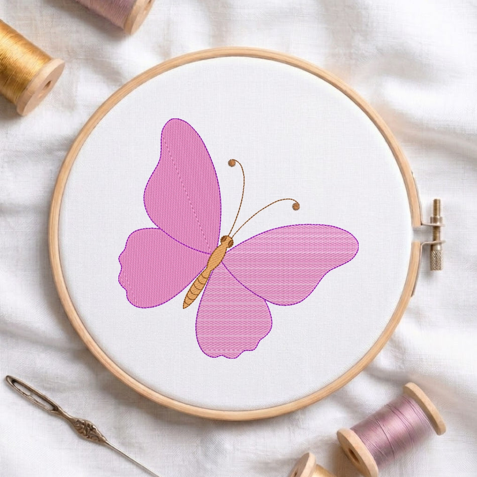 A circular embroidery hoop holding white fabric with a pink butterfly design, surrounded by spools of thread and a needle on a white fabric background.