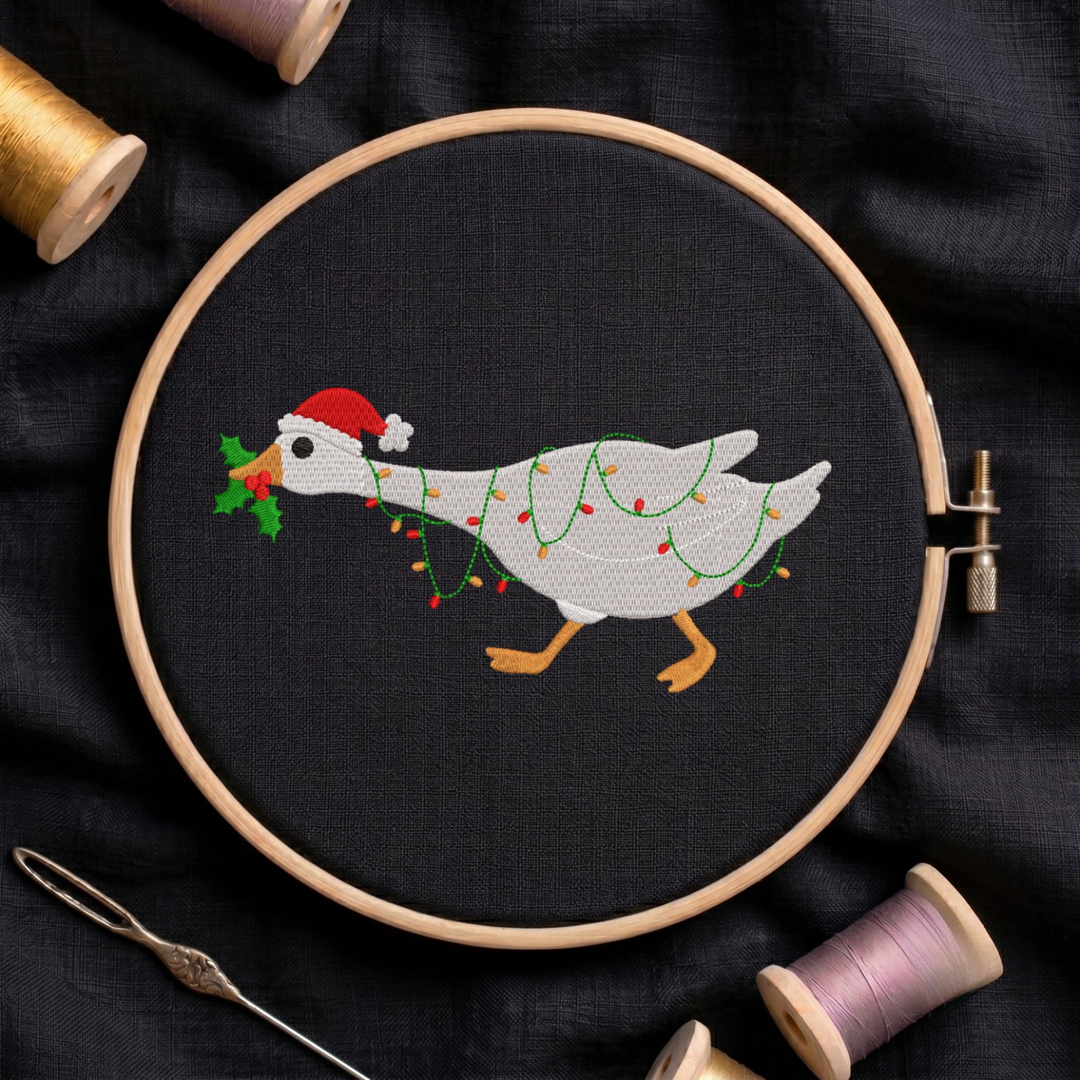 Embroidered Christmas goose wearing a Santa hat and wrapped in fairy lights in a wooden hoop.